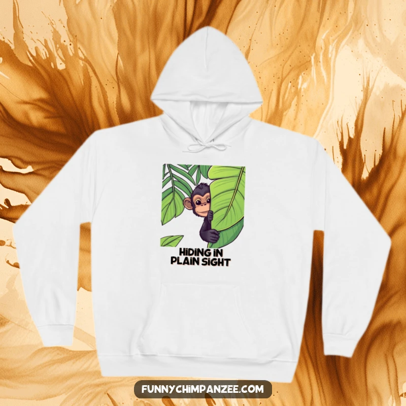Funny Kawaii chimpanzee peeking cheekily from behind a lush jungle leaf on a comfortable hoodie, offering warmth and humor.